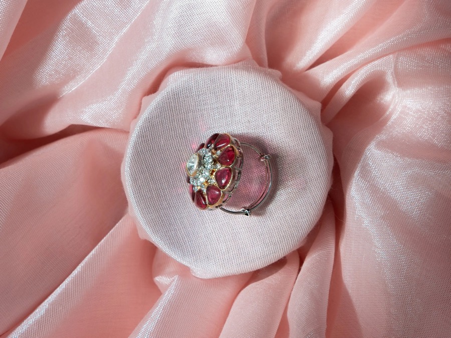 Cocktail ring set with pink and clear stones, shot from above on a pad nested in blush pleats