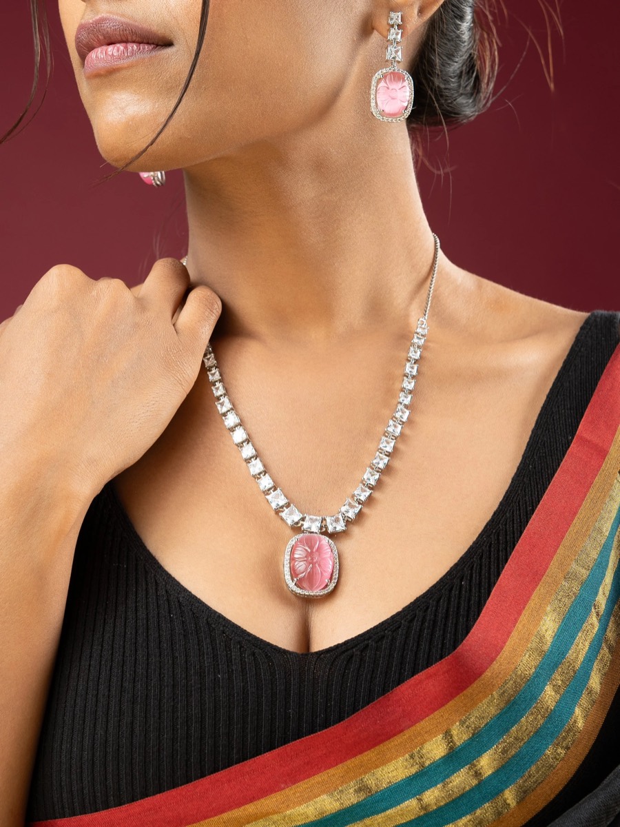 Pink cabochon pendant and matching drops worn over a black top and striped saree for Viraasi