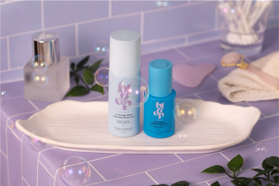 White and cobalt Bloop bottles on a leaf-shaped ceramic tray, lilac tiles and soap bubbles around them