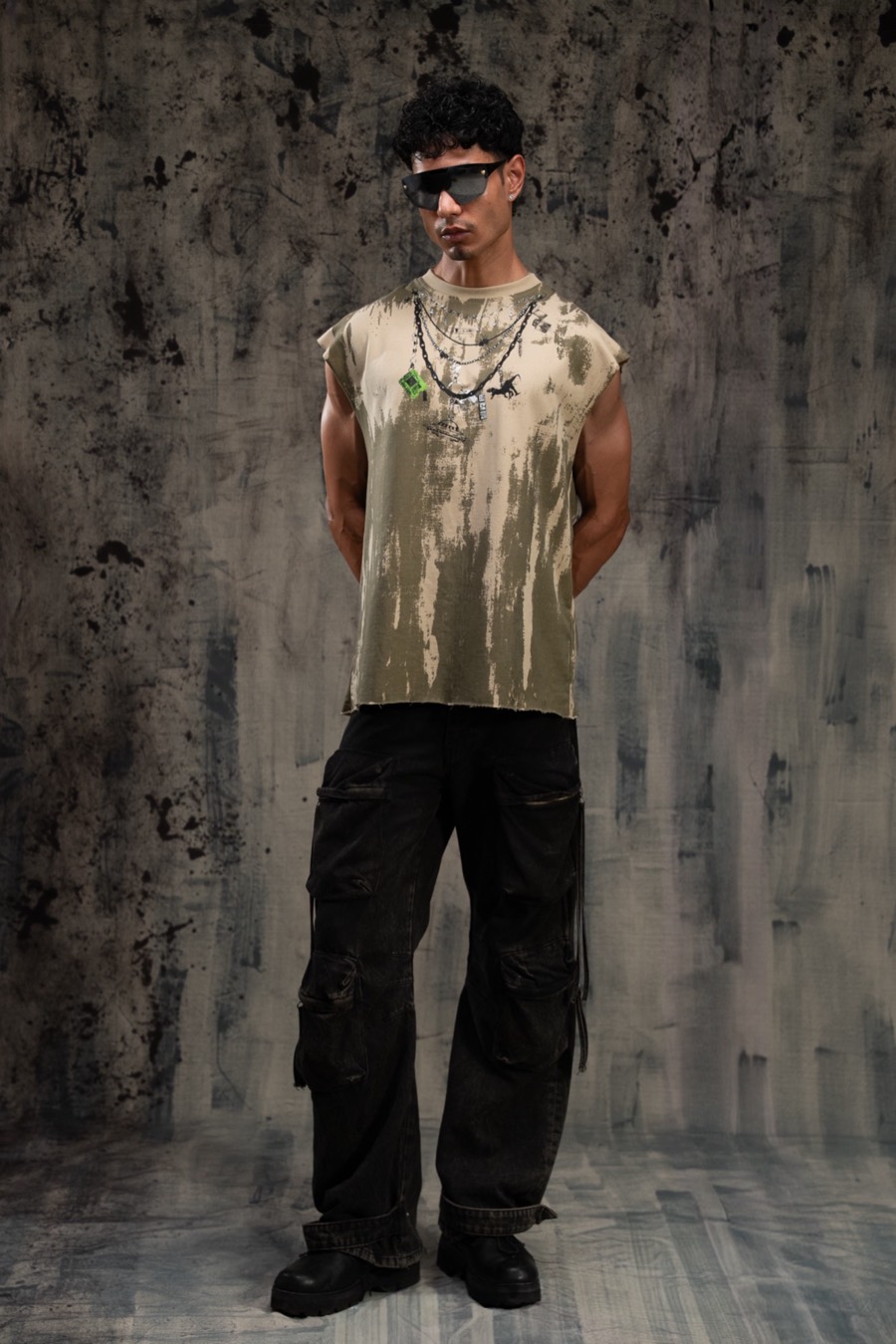 Straight-on stance in a washed khaki tee and strapped black cargo pants, an RF6 lookbook still