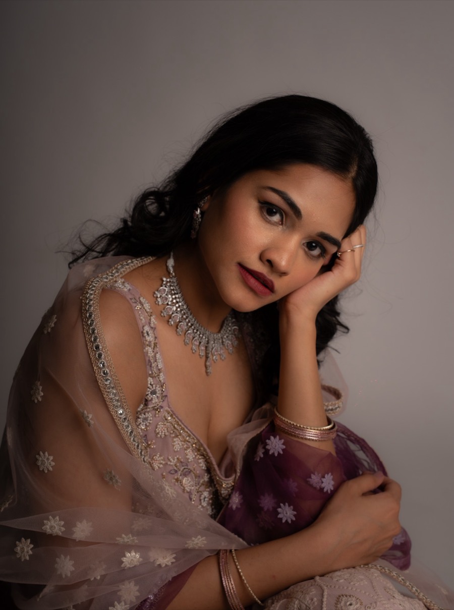 Head propped on one hand, Shreya wears a silver choker and mauve lehenga with a sheer dupatta